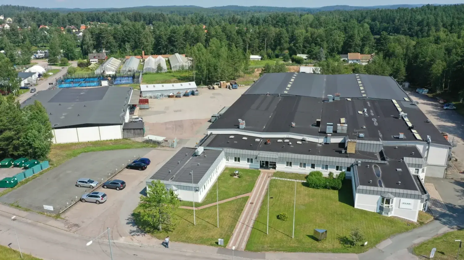 Flygbild över Tranås Rostfrias anläggning med produktionshallar, kontor och parkering