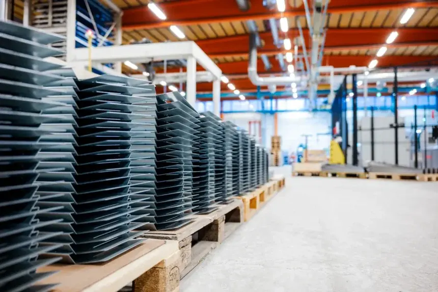 Staplar av färdiga bockade detaljer på pallar i hallen