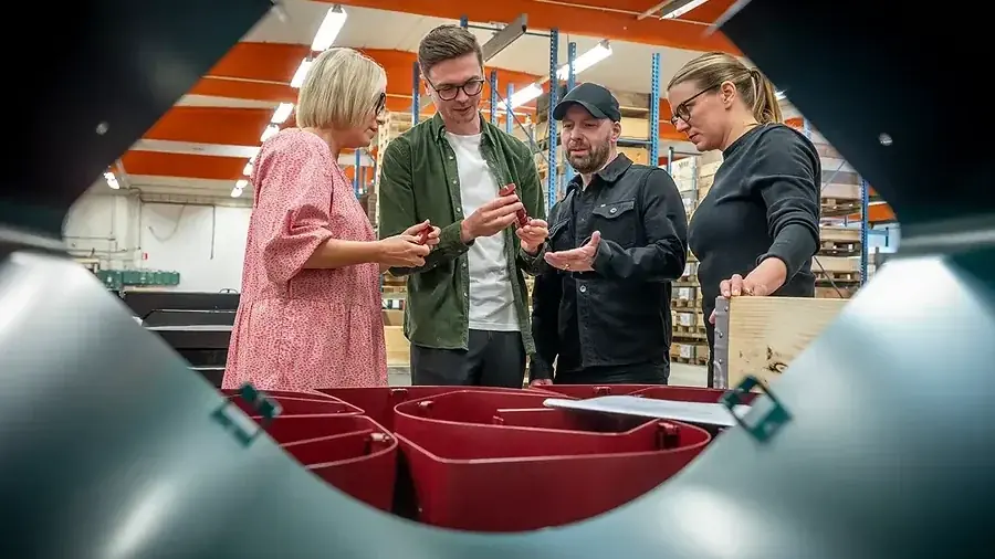 Besökare samlade kring kärlen till KLOSS källsorteringssystem i verkstaden